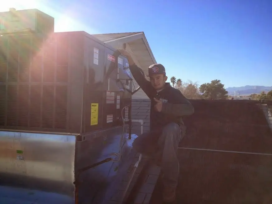 HVAC technician performing Heat Pump Repair on a rooftop unit in Sonoma
